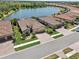 Beautiful aerial view of homes with tile roofs and manicured lawns near a scenic lake in a planned community at 13587 Vancanza Dr, Venice, FL 34293