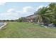 Backyard featuring screened enclosure, lush lawn, and lake view providing a serene outdoor space at 13587 Vancanza Dr, Venice, FL 34293