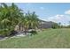 Backyard featuring a screened-in lanai, pool, and lush landscaping offers a private outdoor living space with manicured lawn at 13587 Vancanza Dr, Venice, FL 34293