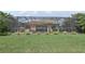 Backyard view featuring screened enclosure, landscaping, and lush green lawn at 13587 Vancanza Dr, Venice, FL 34293