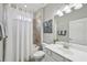 Bright bathroom with a shower and tub combo, white vanity and decorative art at 13587 Vancanza Dr, Venice, FL 34293