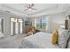 Bright bedroom featuring a tray ceiling, large window, and a comfy seating area at 13587 Vancanza Dr, Venice, FL 34293
