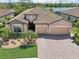 Stunning Mediterranean style home with lush landscaping, brick driveway and serene lake view at 13587 Vancanza Dr, Venice, FL 34293