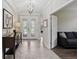 Elegant foyer features tiled floors, a stylish chandelier, and views into the living spaces at 13587 Vancanza Dr, Venice, FL 34293