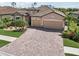 Aerial view of the house with stone accents, tile roof, and brick driveway at 13587 Vancanza Dr, Venice, FL 34293