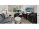 Modern home office with desk, sleek gray sofa, and a large screen television at 13587 Vancanza Dr, Venice, FL 34293