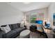 Modern home office with desk, sleek gray sofa, and a large screen television at 13587 Vancanza Dr, Venice, FL 34293