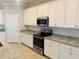 This kitchen features white cabinetry, stainless steel appliances, and granite countertops at 13587 Vancanza Dr, Venice, FL 34293