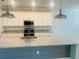 The spacious kitchen features a central island, pendant lights, and stainless steel appliances at 13587 Vancanza Dr, Venice, FL 34293