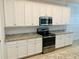 The kitchen showcases white cabinetry, a stainless steel range, and granite countertops at 13587 Vancanza Dr, Venice, FL 34293