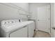 Well-lit laundry room with modern washer and dryer, shelving, and tiled floor at 13587 Vancanza Dr, Venice, FL 34293