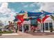 Outdoor seating area with colorful shade structures, tables, and people enjoying the atmosphere at 13587 Vancanza Dr, Venice, FL 34293