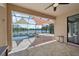 Screened-in patio features a pool, spa, and serene lake view with lovely stone flooring, perfect for outdoor relaxation at 13587 Vancanza Dr, Venice, FL 34293