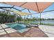 Screened pool features a spa, sunshades, and a beautiful brick paver deck, creating a luxurious outdoor oasis at 13587 Vancanza Dr, Venice, FL 34293
