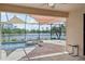 Enclosed pool and spa with sunshades offer a relaxing waterfront escape with a screened-in lanai and stone flooring at 13587 Vancanza Dr, Venice, FL 34293