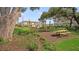 Community park with wooden picnic tables and mulch beds with lush green trees nearby at 15153 Cuzcorro Ct, Nokomis, FL 34275