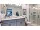 Bathroom with a double sink vanity, shower with glass door, and tasteful decor at 15165 Cuzcorro Ct, Nokomis, FL 34275