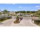 Gated community entrance featuring a pool, landscaping, and pristine streets at 15173 Cuzcorro Ct, Nokomis, FL 34275