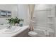 Bright bathroom with vanity, quartz countertop and bathtub-shower with white tile surround at 15173 Cuzcorro Ct, Nokomis, FL 34275