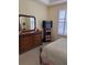 This bedroom features a dresser and large mirror, plus a TV, storage unit and window with blinds at 1620 San Silvestro Dr, Venice, FL 34285