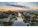 Beautiful waterfront homes line a canal at sunset with clear skies in this appealing aerial view at 1643 Stanford Ln, Sarasota, FL 34231