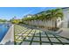 The backyard includes a waterfront view, palm trees, and a geometric lawn, offering a blend of natural beauty and design at 1643 Stanford Ln, Sarasota, FL 34231