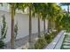A backyard features a garden with palm trees, landscaping, and a white fence, providing a serene outdoor space at 1643 Stanford Ln, Sarasota, FL 34231