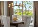 Dining room features a stylish chandelier, and a round table with bright natural light and backyard views at 1643 Stanford Ln, Sarasota, FL 34231