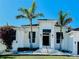 Elegant home exterior featuring palm trees, white columns, and a stately entrance with well-manicured landscaping at 1643 Stanford Ln, Sarasota, FL 34231