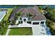 Impressive aerial view of a modern two-story home with manicured lawn, mature palms, and a three-car garage at 1643 Stanford Ln, Sarasota, FL 34231