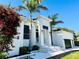 Elegant home featuring a clean white facade, striking architectural details and lush landscaping at 1643 Stanford Ln, Sarasota, FL 34231