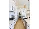 Bright kitchen with stainless steel appliances, white cabinets, and light wood look flooring at 1643 Stanford Ln, Sarasota, FL 34231
