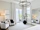 Stylish main bedroom featuring elegant armchairs, modern artwork, and a sliding door to the patio at 1643 Stanford Ln, Sarasota, FL 34231