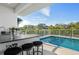 Relax by the pool with an outdoor kitchen and bar area for the perfect staycation at 1643 Stanford Ln, Sarasota, FL 34231