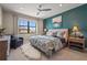 Serene bedroom boasts a teal accent wall, stylish furnishings, and a large window with a view at 16434 Slate Pl, Bradenton, FL 34211