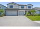 Beautiful two-story home featuring a brick driveway, three-car garage, and tropical landscaping at 16434 Slate Pl, Bradenton, FL 34211