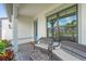 Inviting front porch features comfortable seating with a charming outdoor setting. Plants and tile flooring at 16434 Slate Pl, Bradenton, FL 34211