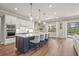 Gourmet kitchen with island seating, stainless steel appliances, quartz countertops, and access to the backyard at 16434 Slate Pl, Bradenton, FL 34211