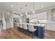Spacious kitchen features a large island with seating, modern appliances, white cabinets, and wood flooring at 16434 Slate Pl, Bradenton, FL 34211