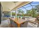 Covered outdoor dining and lounge area with serene views of the pool and landscaping at 16434 Slate Pl, Bradenton, FL 34211