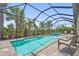 Relaxing screened pool area with a cool blue pool, hot tub, and lush tropical landscaping at 16434 Slate Pl, Bradenton, FL 34211