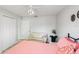 Bright bedroom with a sitting area, ceiling fan, decorative art, and ample closet space at 1667 Oakland Rd, North Port, FL 34286