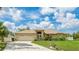 Inviting single-story home with a well-maintained lawn, colorful flower beds, and an attached two-car garage at 1667 Oakland Rd, North Port, FL 34286