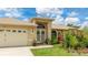 Close-up of the home's inviting front entrance with a well-manicured lawn and colorful flower beds at 1667 Oakland Rd, North Port, FL 34286