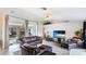 Cozy living room showcasing leather seating, a TV, and a view of the screened-in pool area at 1667 Oakland Rd, North Port, FL 34286