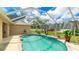 Screened-in pool with water feature and lush landscaping at 1667 Oakland Rd, North Port, FL 34286