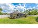 Backyard view showcasing a screened-in pool, lush lawn, and privacy fence at 1667 Oakland Rd, North Port, FL 34286