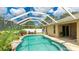 Enclosed pool area features lush landscaping and comfortable seating at 1667 Oakland Rd, North Port, FL 34286