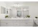 Bright bathroom featuring double sinks, white cabinetry, and modern decor elements at 17510 Gawthrop Dr # 208, Bradenton, FL 34211