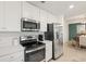Kitchen featuring stainless steel appliances, white cabinets, and adjacent dining area at 17510 Gawthrop Dr # 208, Bradenton, FL 34211